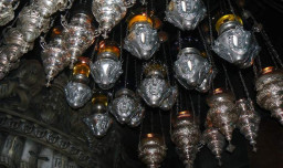 Lampy oliwne od rĂłĹĽnych wyznaĹ„ chrzeĹ›cijaĹ„skich zawieszone w komorze Grobu Chrystusa. 